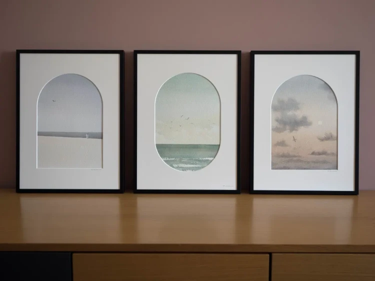 Reprodukcje w aluminiowych czarnych ramach i passe-partout, od lewej: "Nad brzegiem", "Bezkres", "Obłoki"